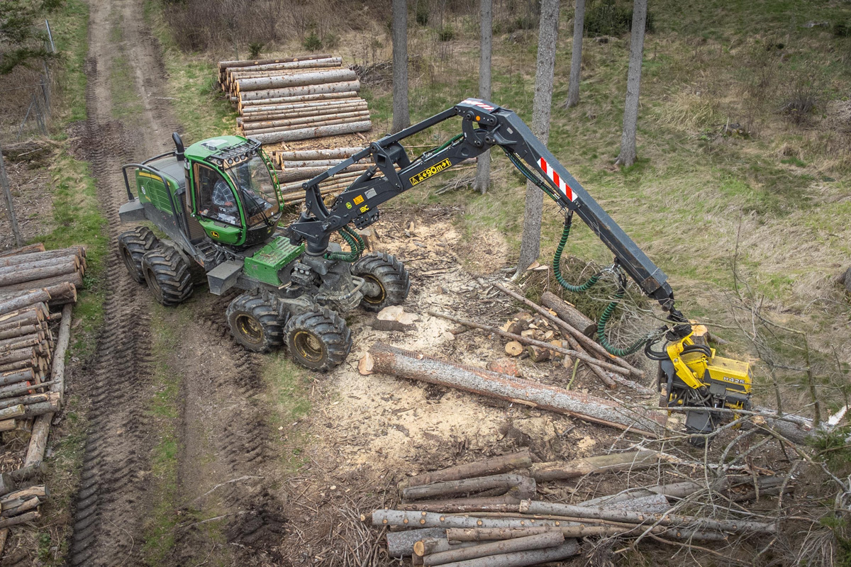 Harvester bei der Jungdurchforstung mit gepoltertem Stammholz